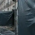 Bache de chantier PVC tendue sur échafaudage, œillets et sandows pour sécuriser les travaux