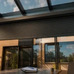 Volet roulant veranda aluminium sous toiture vitrée, store mi-ouvert